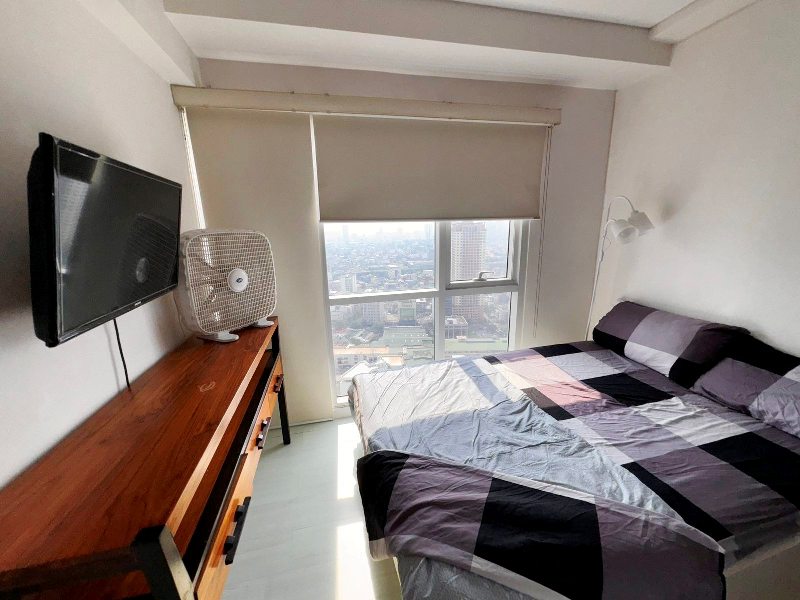 fully furnished 2-bedroom unit in Senta Makati with a balcony facing the park and Manila