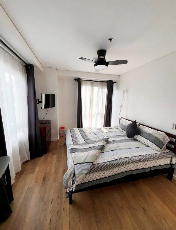 fully furnished 2-bedroom unit in Senta Makati with a balcony facing the park and Manila